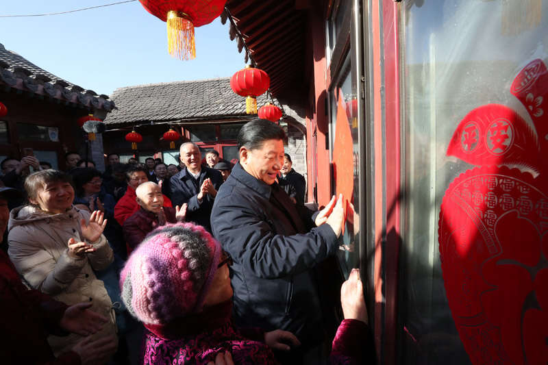 2019年2月1日上午，習(xí)近平在北京前門東區(qū)草廠四條胡同32號院，高興地拿起一幅“?！弊?，親自貼到門上，給這里的老街坊們拜年。新華社記者 鞠鵬 攝